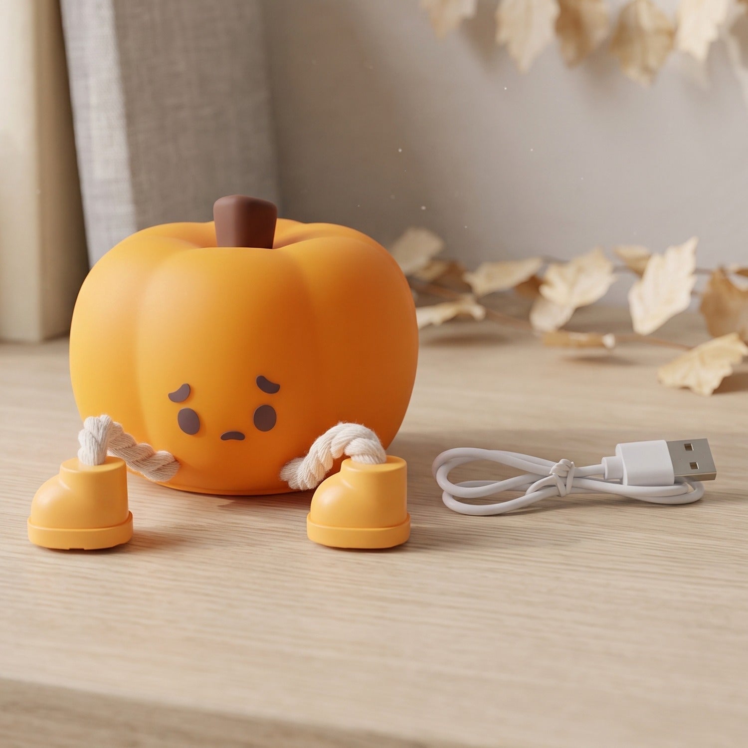 Soft silicone pumpkin night light, USB rechargeable, glowing warmly. Image 4 of 9.